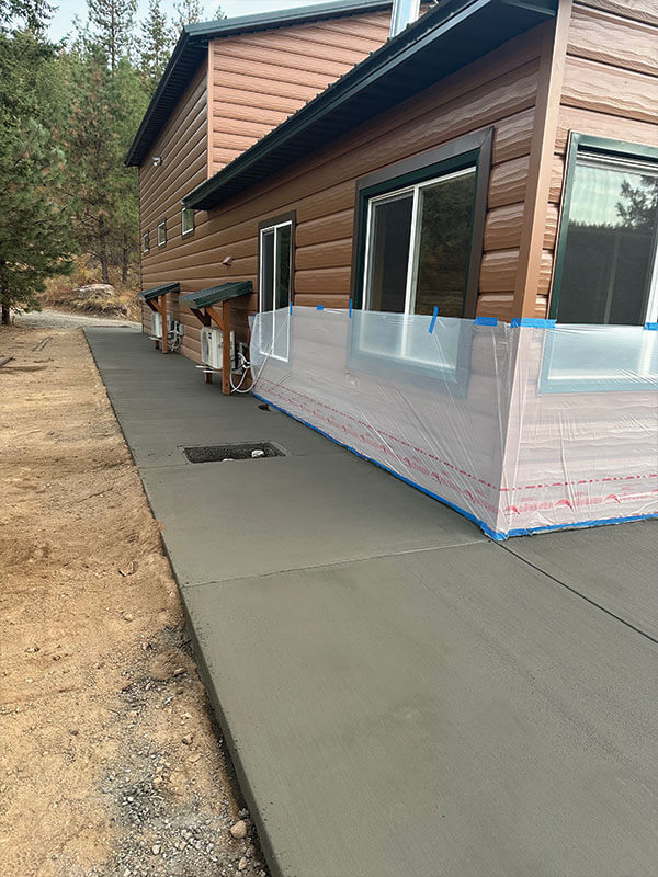 New concrete walkway alongside a cedar-sided home remodel near Davenport, WA