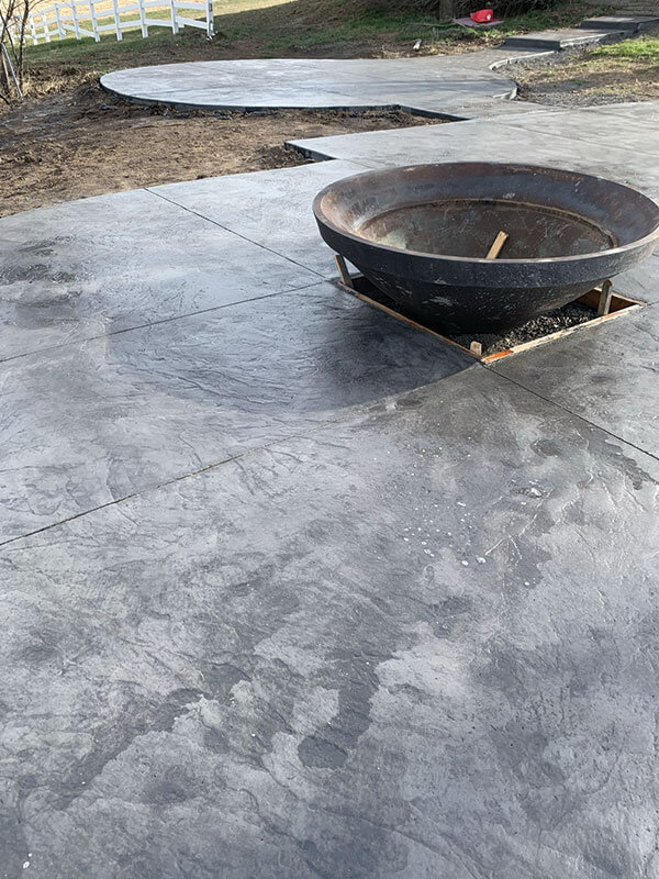 Decorative stamped concrete patio with built-in fire feature
